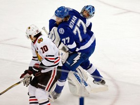 Ben Bishop of the Tampa Bay Lightning collides with teammate Victor Hedman, right, as Patrick Sharp, left, of the Chicago Blackhawks skates past them with the puck on his way to scoring a goal in the first period Game Five of the 2015 NHL Stanley Cup Final on June 13, 2015. (Mike Carlson/Getty Images/AFP)