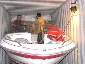 Loads of Love volunteers loaded a boat and other supplies into a shipping container on Saturday. The container is going from Chatham to a summer camp for orphans in the Ukraine.