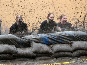 A team of four in the inaugural Assante Dirty Dash for Rebound careen into a mud pit at the bottom of one of 16 obstacles set up for the mud run fundraiser at Canatara Park Saturday. Organizers expect the event raised more than $30,000 for Rebound programs. Tyler Kula/Sarnia Observer/Postmedia Network