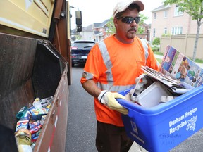 Worker Rob Moyer collects blue boxes and green bins along Gillett Dr. in Ajax on June 5. (VERONICA HENRI, Toronto Sun)
