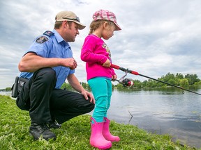 Special Const. Ben Lupenette helps his four-year-old daughter, Ruby, fish at Victoria Park on Sunday June 14, 2015 in Belleville, Ont. They were among the hundreds of people who participated in this years Kids, Cops & Canadian Tire fishing derby. Tim Miller/Belleville Intelligencer/Postmedia Network