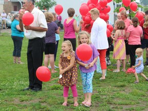 Alivia Awde and Jewelia Awde, from Richwood United Church, get ready to release their balloons into the air during Oxford's 90th anniversary celebration for the United Church of Canada on Sunday, June 14. (MEGAN STACEY/Sentinel-Review)