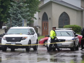 Police block access to the rear of a strip mall at Huron Street and Highbury Avenue where an 18-year-old male was shot dead around 5.20 a.m. in London, Ont. on Sunday June 14, 2015. Three suspects have been arrested. Craig Glover/Postmedia Network
