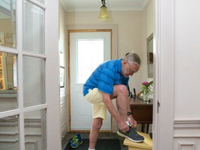 Ray Jones ties his running shoes at his home in London. The 79 year old will be one of dozens of runners who will carry the Pan Am torch when it passes through the London area Wednesday and Thursday. (CRAIG GLOVER, The London Free Press)