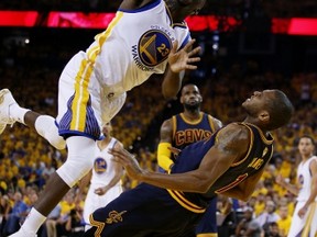 Draymond Green of the Warriors falls over the Cavaliers’ James Jones in Oakland on Sunday night. (AFP)