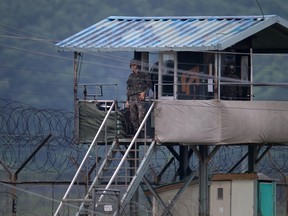 In a file photo taken on June 7, 2013 a South Korean soldier looks out from his guard post near the Demilitarized Zone (DMZ) dividing the two Koreas near the border area of Imjingak. AFP PHOTO / FILES / Ed Jones