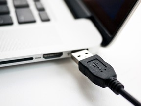 A file photo illustration shows a USB device being plugged into a laptop computer in Berlin July 31, 2014. REUTERS/Thomas Peter/Files