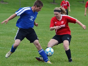 Danielle Patton (right) of the Mitchell U21 co-ed soccer team battles for the ball against this Shakespeare opponent during league action last Friday, June 12 at Parmalat field, a 2-1 loss. GALEN SIMMONS/MITCHELL ADVOCATE