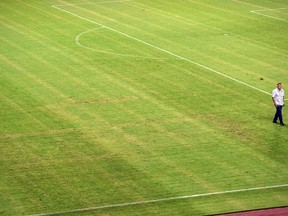 A man walks on the pitch appearing to show the pattern of a swastika following the the Euro 2016 qualifying football match between Croatia and Italy at the Poljud stadium in Split on June 12, 2015. (AFP PHOTO/ANDREJ ISAKOVIC)