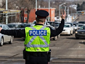 Police direct traffic at 97 Avenue and 105 Street after a single vehicle collision occurred under the 97 Avenue Tunnel in Edmonton, Alta., on Wednesday, March 25, 2015. Codie McLachlan/Edmonton Sun