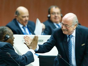 FIFA President Sepp Blatter, right, and Issa Hayatou, Senior Vice President of the FIFA, do a Handshake For Peace at the 65th FIFA Congress in Zurich, Switzerland on May 29, 2015. The initiative, created by the Nobel Peace Center, is in jeopardy now that the centre announced it is cutting ties with FIFA. (REUTERS/Arnd Wiegmann)
