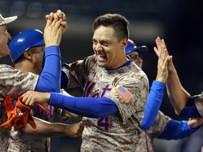 New York Mets shortstop Wilmer Flores, right, celebrates his game-winning hit against the Toronto Blue Jays with teammates at Citi Field. The Mets defeated the Blue Jays 4-3 in eleven innings. (Brad Penner-USA TODAY Sports)