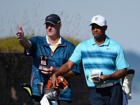 Caddie Joe LaCava (left) speaks with Tiger Woods during a practice round for U.S. Open Championship on Monday.  (Getty Images/AFP)