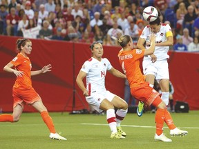 Canada forward Christine Sinclair heads the ball as Netherlands’ Mandy Van Den Berg defends during last night’s 1-1 draw. (USA TODAY SPORTS)