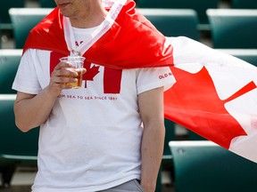 A Canada fan drinks a beer before a FIFA Women's World Cup 2015 match between Canada and China at Commonwealth Stadium in Edmonton, Alta., on Saturday June 6, 2015. Ian Kucerak/Postmedia Network