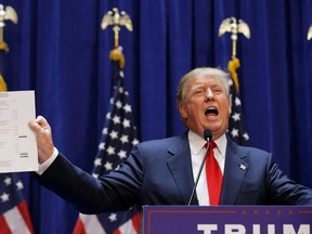 U.S. Republican presidential candidate, real estate mogul and TV personality Donald Trump holds up his financial statement showing his net worth as he formally announces his campaign for the 2016 Republican presidential nomination during an event at Trump Tower in New York, on June 16, 2015. (REUTERS/Brendan McDermid)