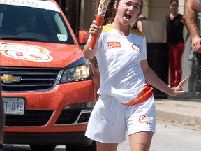 Pan American Games Torch Relay torchbearer Melanie Lozon dances her way down James Street with the torch on June 16. Lozon, a Chatham native, was one of 11 Pan Am relay torchbearers who took the torch acoss Wallaceburg.