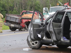 A Kingston firefighter takes notes at the scene of a two-vehicle collision at the intersection of Battersea and Kingston Mills roads in Kingston, Ont. on Tuesday, June 16, 2015. 
Elliot Ferguson/Kingston Whig-Standard/Postmedia Network