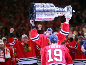 Chicago Blackhawks captain Jonathan Toews, front, passes the Stanley Cup to veteran Kimmo Timonen after defeating the Tampa Bay Lightning in game six. But this scene almost didn't take place after floods delayed the arrival of the prized trophy to the United Center. (Dennis Wierzbicki/USA TODAY Sports)