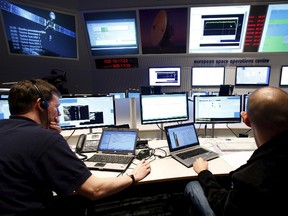 Flight engineers work in the main control room of the European Space Operations Centre (ESOC) in Darmstadt, Germany, in this file picture taken January 20, 2014. The Philae lander space probe thought lost has woken up some seven months after officials thought it marooned in the shadows of a comet, the European Space Agency said on June 14, 2015.  REUTERS/Ralph Orlowski/Files