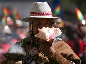 A witch doctor blows a shell during a May Day demonstration on Labour Day in La Paz May 1, 2014. REUTERS/Gaston Brito