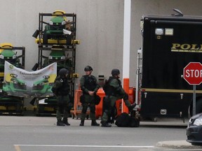 Armed officers stand outside the Canadian Tire store in Timmins where an armed man has barricaded himself Wednesday morning.