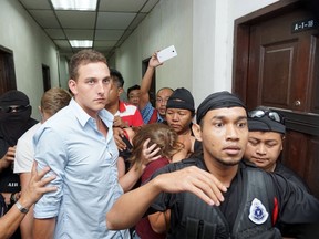 Dutch national Dylan Snel (4th L) leaves a court hearing along with Canadian siblings Lindsey (3rd L, obscured) and Danielle Petersen (C, with face obscured) and British national Eleanor Hawkins (3rd R, obscured) in Kota Kinabalu, Malaysia's eastern Sabah state June 12, 2015. The four Western tourists who posed naked on top of Malaysia's tallest peak and were blamed by some for a deadly earthquake six days later were sentenced to three days in jail and fined on Friday after they admitted obscene behaviour. They will also be deported. REUTERS/Stringer