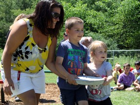 SARAH HYATT/THE INTELLIGENCER
Early Childhood Educator Wendy DesRosiers (left) helps SK student Jaxon Ricketts and JK student Bethany Kirby lay a classroom stone during Stirling Public School's celebration of a new and transformed playground, in Stirling Wednesday.