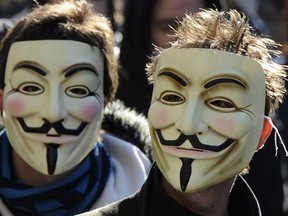 Two members of Anonymous sporting Guy Fawkes masks. 

AFP PHOTO/JOHANNA LEGUERRE