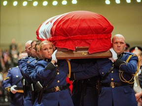 The Edmonton Police Service Casket Detail carries the coffin of fallen Edmonton Police officer Cst. Daniel Woodall into the Shaw Conference Centre
