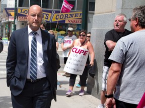 Mayor Matt Brown is heckled by striking CUPE 101 members and their supporters as he walks to a meeting with Premier Kathleen Wynne on Dundas St. in London Wednesday, June 24, 2015. (DEREK RUTTAN, The London Free Press)