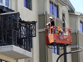 Workmen examine the damage at the scene of a 4th-story apartment building balcony collapse in Berkeley, California June 16, 2015. Six people were killed, including five young Irish citizens, and at least seven other people were injured when an apartment balcony collapsed early on Tuesday in the Californian city of Berkeley, Ireland's foreign minister said.  REUTERS/Elijah Nouvelage