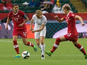 Team Canada's Christine Sinclair (left) and Sophie Schmidt (right) battle the New Zealand's Betsy Hassett (centre) during Women's World Cup action in Edmonton on Thursday, June 11, 2015. (David Bloom/Postmedia Network)