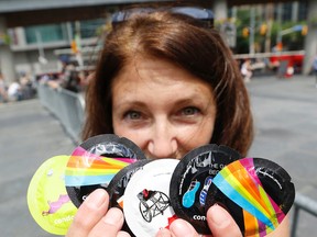Lesley Belows, of Toronto Public Health, holds all six of the lasty year's City of Toronto branded condoms at Dundas Square in June 2015. (Michael Peake/Toronto Sun)