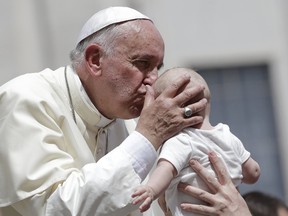 Pope Francis kisses a baby as he leaves at the end of his Wednesday general audience in Saint Peter's square at the Vatican on June 17, 2015. (REUTERS/Max Rossi)