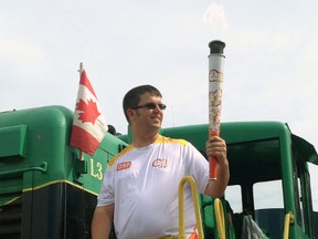 Andrew Poole presents the Toronto 2015 Pan Am Torch to the crowd gathered at the L&PS station Wednesday. The torch made a stop in St. Thomas as part of its 41-day relay across the country ahead of the international sporting event.