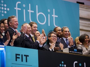 James Park, centre, Fitbit CEO, applauds with co-founder and CTO Erid Friedman (6th L) while ringing the opening bell on the day of the company's IPO above the floor of the New York Stock Exchange, June 18, 2015. (REUTERS/Lucas Jackson)