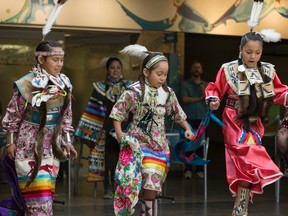 (Left to right)  Alexandra Yellowbird, 11, Pisim Yellowbird, 8, and Ryley Hunter, 10, with Heavenly Skies Dance Society, perform a woman's dance at Muttart Conservatory in Edmonton, Alta., on Saturday, June 21, 2014. June 21 is National Aboriginal Day.