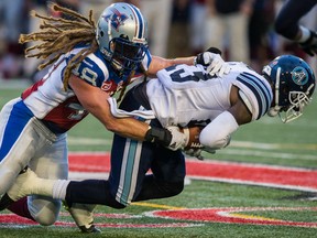 Alouettes linebacker Bear Woods, (left) tackles Argonauts wide receiver Kevin Elliott during pre-season CFL action on Thursday night in Montreal. (DARIO AYALA/POSTMEDIA NETWORK)