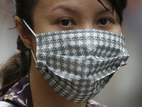 A woman, wearing a mask to prevent contracting Middle East Respiratory Syndrome (MERS), walks on a street in central Seoul, South Korea, June 15, 2015. Picture taken June 15, 2015. REUTERS/Kim Hong-Ji