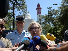 French subprefect of Gironde department Dominique Christian and commander of gendarmerie Jean-Philippe Viadalo speak to journalists in front of the ligthouse of Cap-Ferret in Lege-Cap-Ferret, western France. A 12 year old girl made a fatal fall on June 18 while doing a roped aerobatic display at the lighthouse as part of rehearsals for the French TV show "Favorite Monument of French." (AFP/JEAN-PIERRE MULLER)