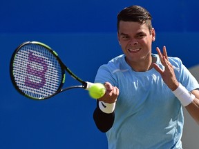 Canada's Milos Raonic returns the ball to France's Gilles Simon during their quarter final match at the ATP Aegon Championships tennis tournament at the Queen's Club in west London on June 19, 2015.     AFP PHOTO / LEON NEAL