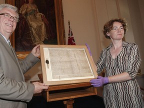 Premier Greg Selinger and Oxford University Conservator Madeline Slaven hold the Magna Carta at the Manitoba Legislature in July 2010. The Magna Carta will return to Winnipeg in August as part of an exhibit at the human rights museum. (MARCEL CRETAIN/Winnipeg Sun file photo)