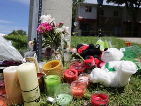 A makeshift memorial of flowers, candles and teddy bears rests on Friday, June 19, 2015 across the parking lot from where Kaitlan Babcock was killed Thursday morning at unit 21 at 312 Conacher Drive in Kingston, Ont.
Elliot Ferguson/Kingston Whig-Standard/Postmedia Network
