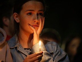 A woman holds a candle during a candlelight vigil at the Martin Luther King Jr. Civic Center Park to mourn the loss of six students who died in an early Tuesday morning balcony collapse on June 17, 2015 in Berkeley, California. Hundreds of people attended a candlelight vigil for six students who were killed, five of which were in the United States on J1 work visas from Ireland, when a balcony they were standing on collapsed during a birthday party in their Berkeley, California apartment.  Justin Sullivan/Getty Images/AFP