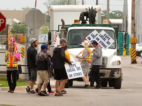 Striking inside city workers block trucks from leaving a city lot on Bathurst Street in London, Ont. on Friday June 12, 2015. (MIKE HENSEN, The London Free Press)