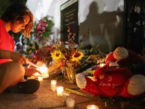 A woman lights candles for the nine victims of last night's shooting at the historic Emanuel African Methodist Episcopal Church June 18, 2015 in Charleston, South Carolina. Dylann Storm Roof, 21, of Lexington, South Carolina, who allegedly attended a prayer meeting at the church for an hour before opening fire and killing three men and six women, was arrested today. Among the dead is the Rev. Clementa Pinckney, a state senator and a pastor at Emanuel AME, the oldest black congregation in America south of Baltimore, according to the National Park Service.  Chip Somodevilla/Getty Images/AFP