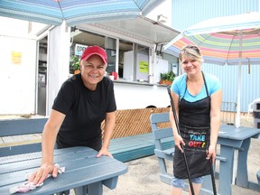 Co-owners Jennifer Symes and Tammylee Desjardins clean the tables at the Off The Wagon food truck in Garson. Gino Donato/Sudbury Star