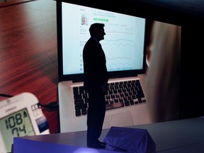 Telus executive chairman Darren Entwistle is silhouetted against a projection screen as he announces that Telus is bringing fibre-optic Internet to Edmonton Alta. on Friday June 19, 2015. The $1-billion infrastructure investment will reach 90 per cent of buildings and homes. David Bloom/Edmonton Sun/Postmedia Network