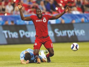TFC forward Jozy Altidore gets tripped up by New York City FC defender Chris Wingert during Saturday night’s game at BMO Field. (USA TODAY SPORTS)
